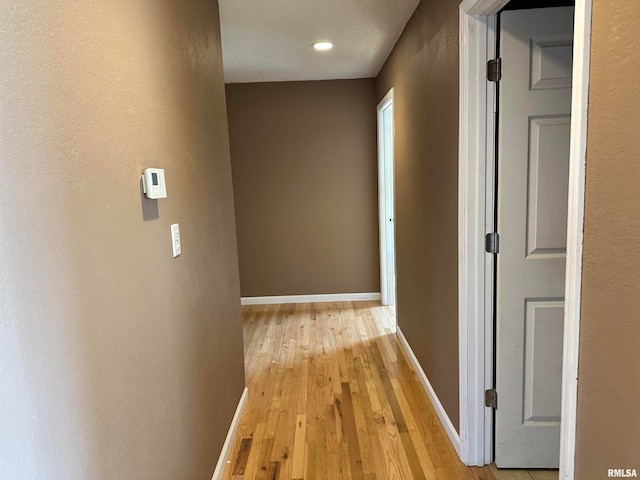 hallway with light hardwood / wood-style floors