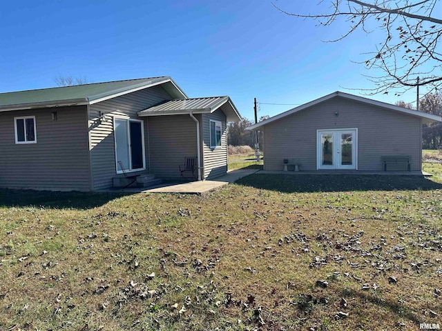 rear view of house featuring french doors, a yard, and a patio area