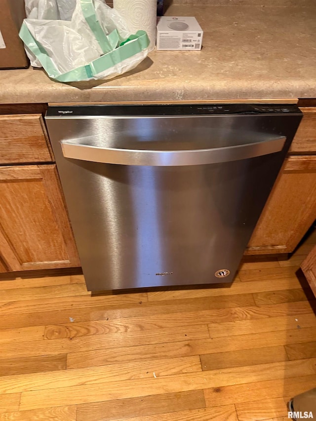 interior details featuring light hardwood / wood-style flooring and stainless steel dishwasher