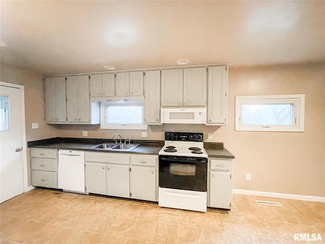 kitchen featuring white cabinetry, sink, light tile patterned floors, and white appliances