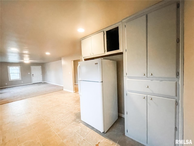 kitchen featuring white fridge and white cabinetry