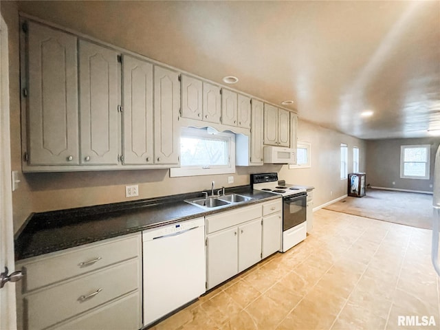 kitchen with light tile patterned flooring, white appliances, white cabinetry, and sink