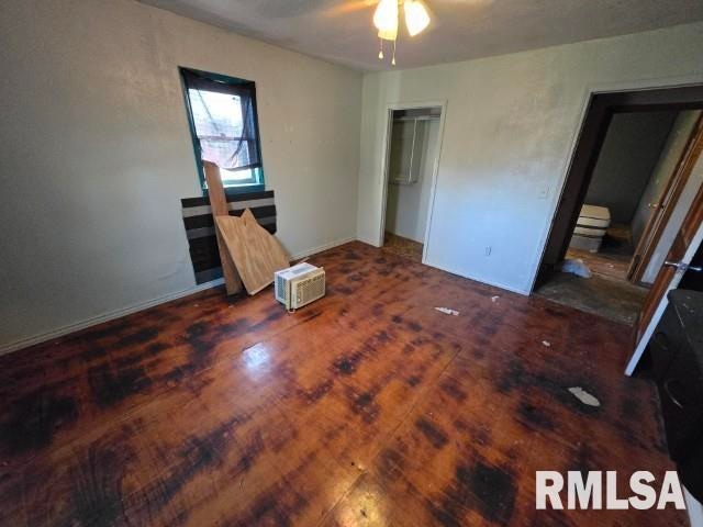 unfurnished bedroom featuring ceiling fan and dark wood-type flooring