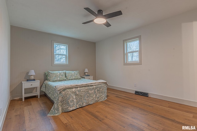 bedroom featuring multiple windows, ceiling fan, and hardwood / wood-style flooring