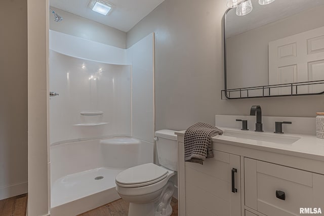 bathroom with a shower, wood-type flooring, vanity, and toilet