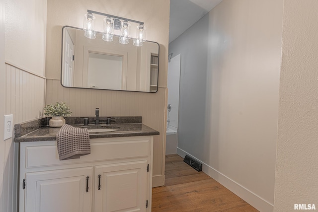 bathroom featuring shower / bathing tub combination, hardwood / wood-style floors, and vanity