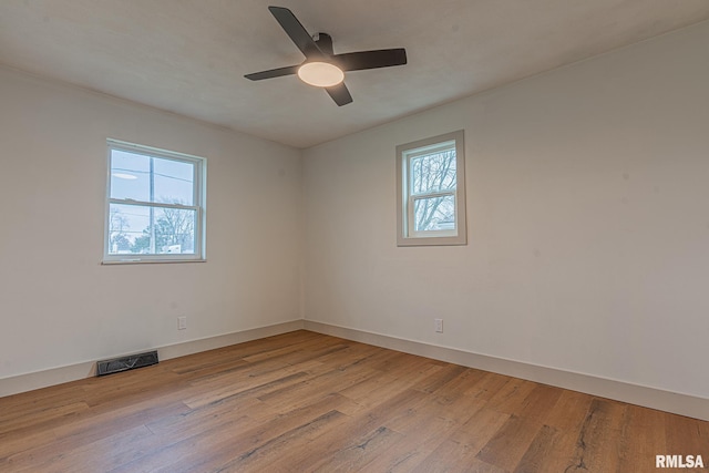 empty room with light hardwood / wood-style floors, plenty of natural light, and ceiling fan