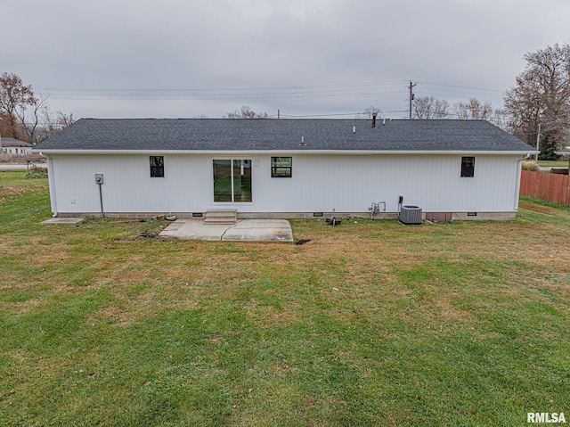 rear view of property with a lawn, a patio, and central AC unit