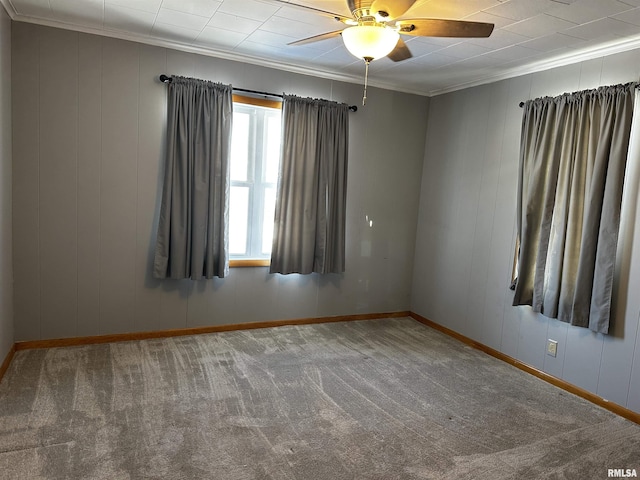 carpeted spare room featuring crown molding and ceiling fan