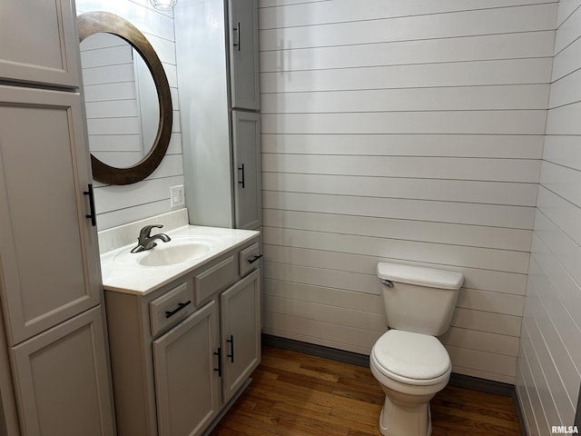 bathroom with vanity, wood-type flooring, and toilet