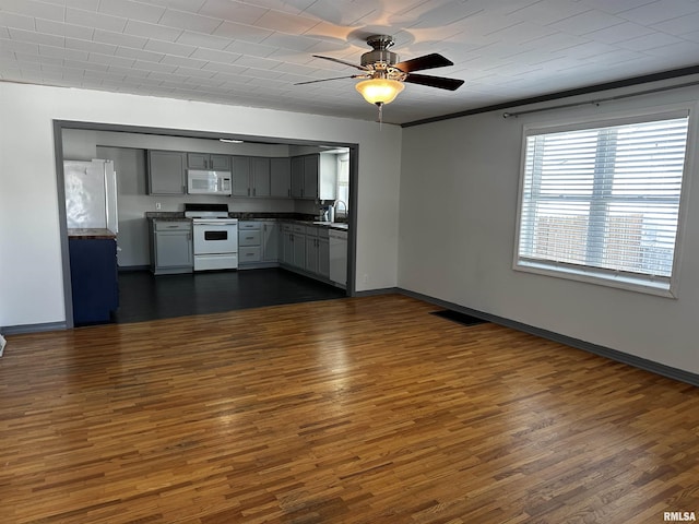 kitchen featuring white appliances, sink, dark hardwood / wood-style floors, gray cabinets, and ceiling fan