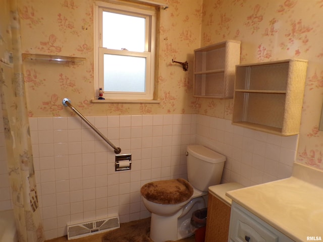 bathroom featuring vanity, toilet, and tile walls