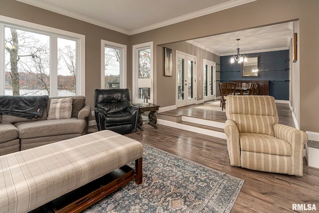 living room featuring hardwood / wood-style floors, an inviting chandelier, and crown molding