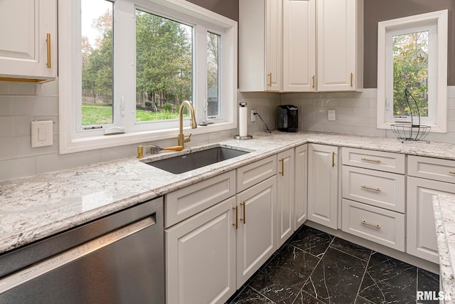 kitchen with dishwasher, backsplash, white cabinets, and sink