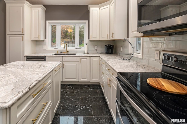 kitchen featuring white cabinetry, sink, appliances with stainless steel finishes, and tasteful backsplash