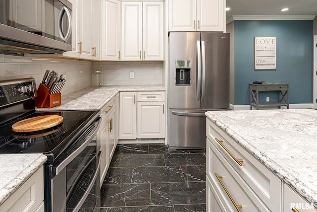 kitchen featuring white cabinetry, light stone countertops, decorative backsplash, appliances with stainless steel finishes, and ornamental molding