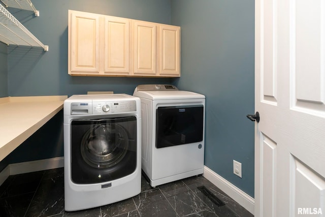 clothes washing area featuring cabinets and independent washer and dryer