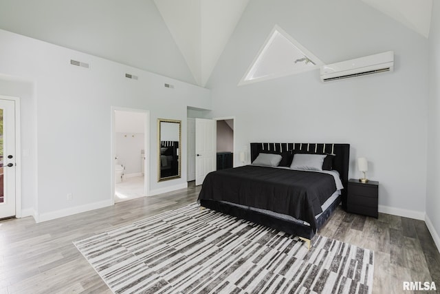 12225 Pebble Point Rd, Marion, IL 62959 - bedroom with a wall mounted air conditioner, wood finished floors, baseboards, high vaulted ceiling, and ensuite bathroom
