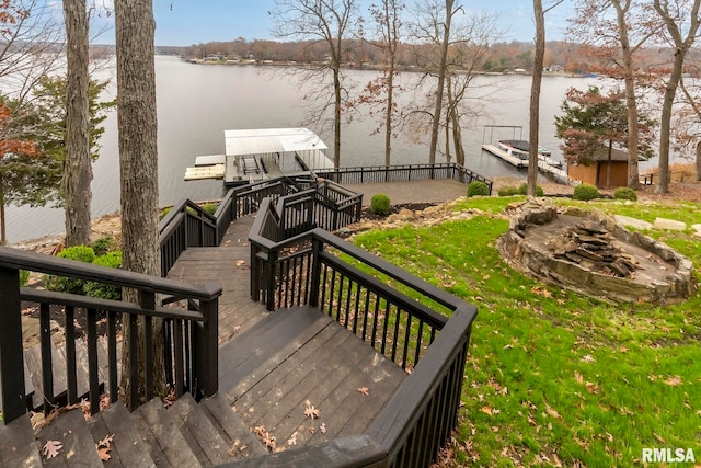 exterior space featuring a dock, a water view, and a fire pit