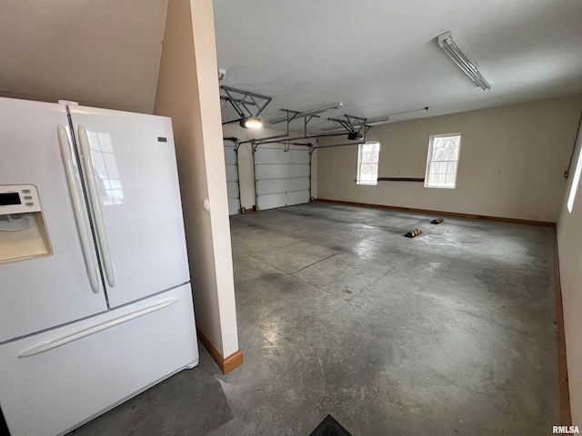 garage with a garage door opener and white fridge with ice dispenser