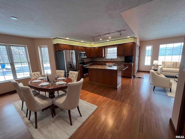 dining room featuring a textured ceiling and light hardwood / wood-style flooring