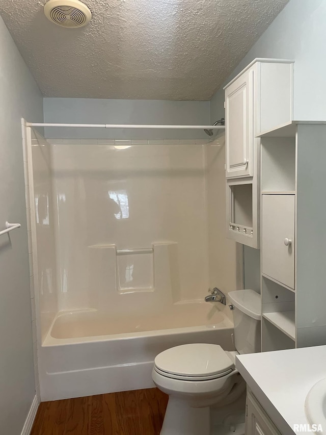 full bathroom with vanity, wood-type flooring, a textured ceiling, and toilet