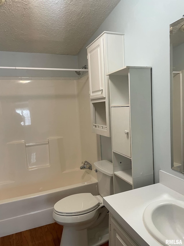 full bathroom with hardwood / wood-style floors, vanity, toilet, a textured ceiling, and tub / shower combination