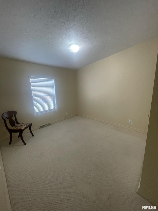 carpeted empty room with a textured ceiling