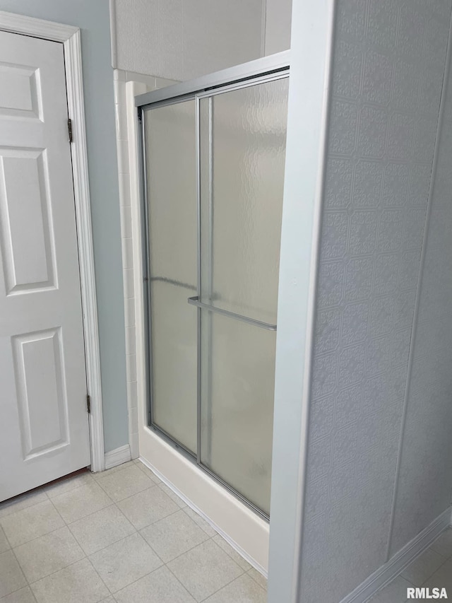 bathroom featuring a shower with door and tile patterned flooring