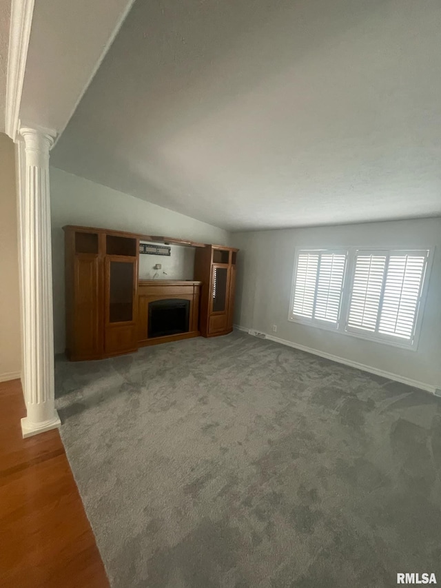 unfurnished living room with carpet, ornate columns, and lofted ceiling