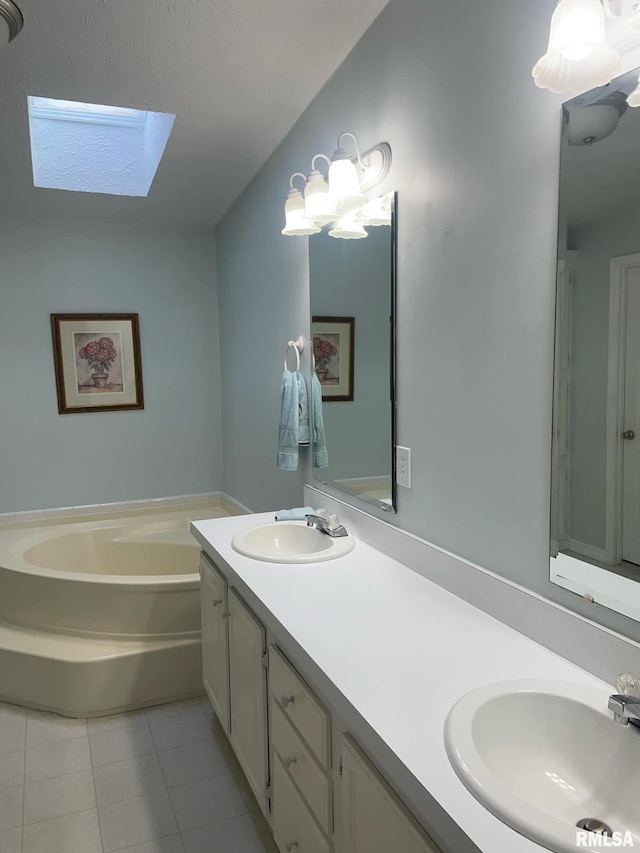 bathroom with tile patterned flooring, vanity, a bath, and a skylight