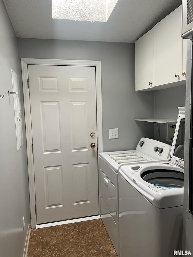 clothes washing area with washing machine and dryer and cabinets