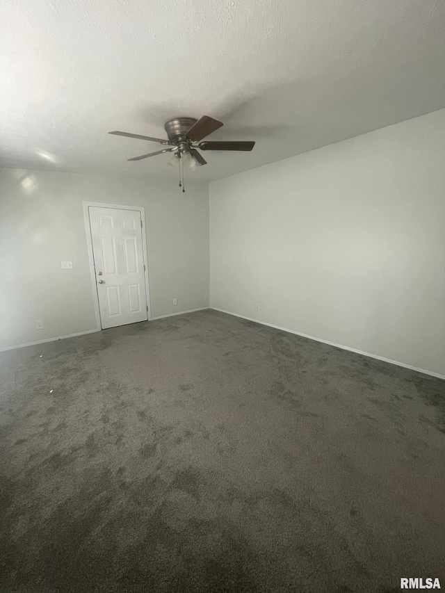 carpeted spare room featuring ceiling fan and a textured ceiling