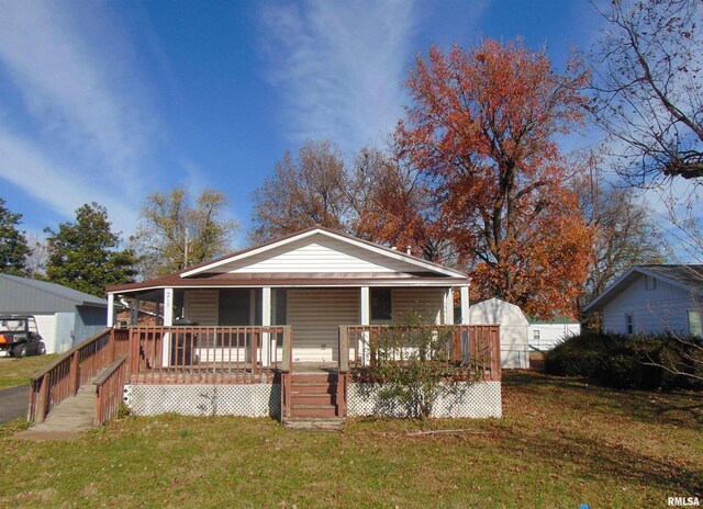 view of front of property featuring covered porch and a front lawn