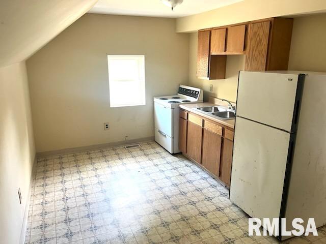 kitchen with lofted ceiling, sink, and white appliances