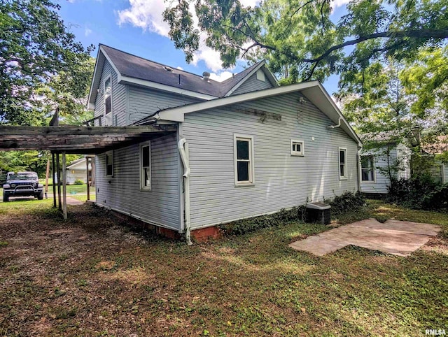 view of side of home featuring a carport and central AC