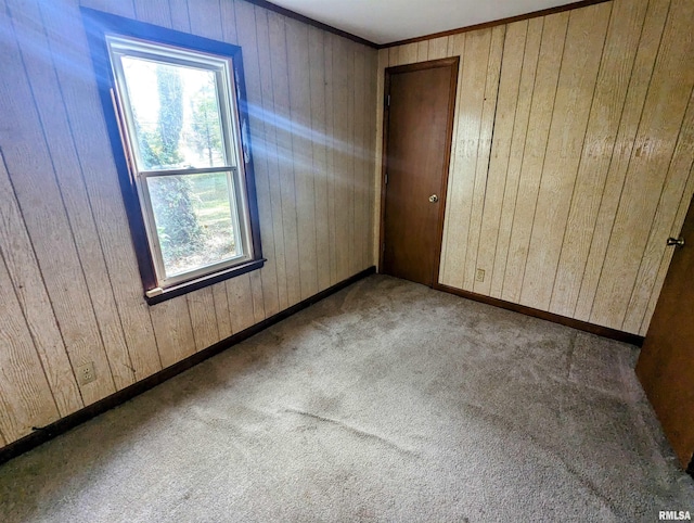 unfurnished bedroom with light colored carpet, wooden walls, and a closet