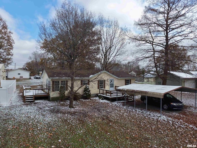 snow covered property featuring a wooden deck and a carport