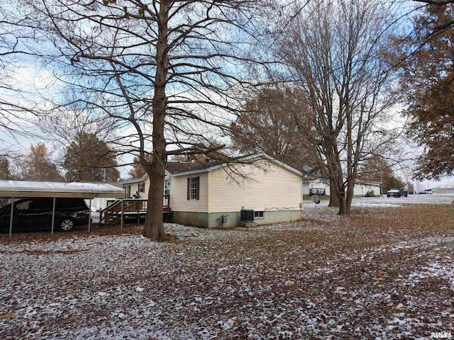 view of snow covered exterior featuring a deck and a carport