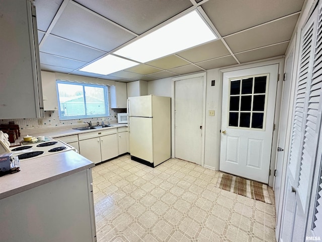 kitchen featuring decorative backsplash, white appliances, a drop ceiling, and sink