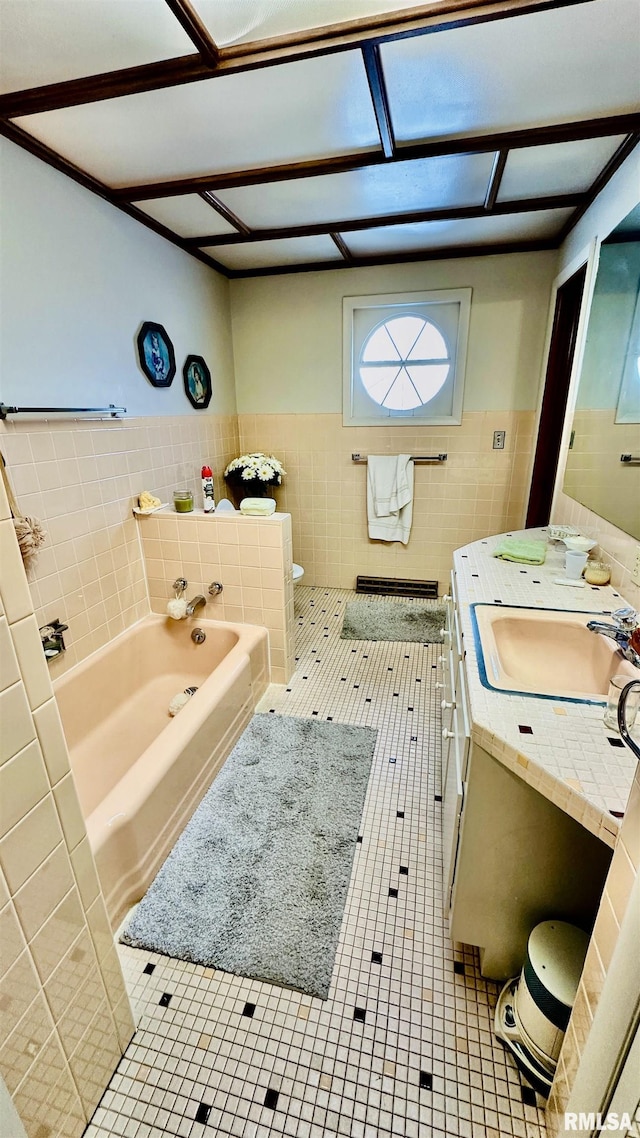 bathroom with tile patterned flooring, vanity, tile walls, and a washtub