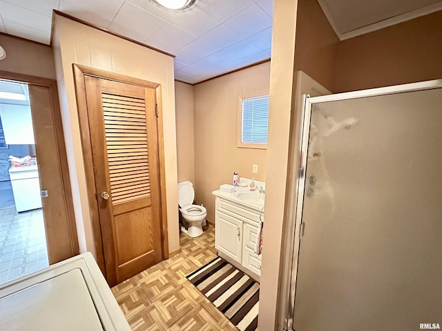 bathroom featuring a shower with shower door, toilet, parquet flooring, and vanity