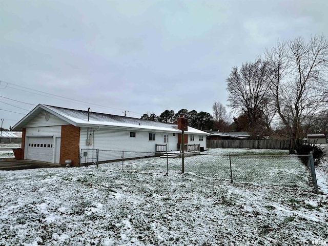 snow covered property with a garage