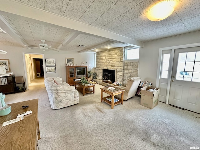 carpeted living room with a wood stove and ceiling fan