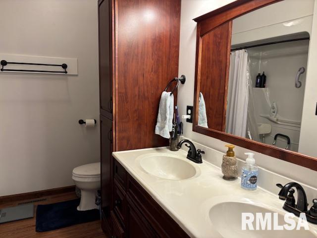 bathroom featuring vanity, hardwood / wood-style floors, a shower with shower curtain, and toilet