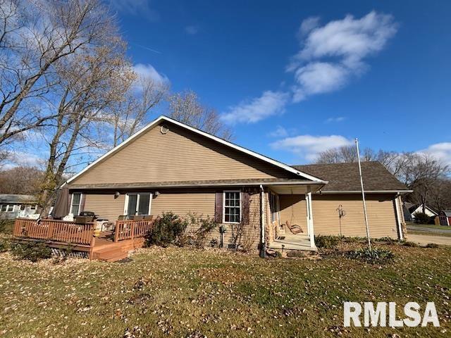 rear view of property with a yard and a wooden deck