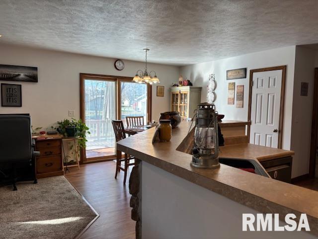 dining room featuring dark hardwood / wood-style floors, a textured ceiling, and a chandelier