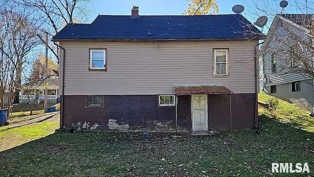 rear view of property featuring a yard