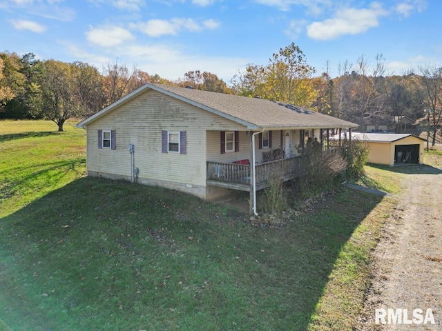 view of side of property with an outbuilding, a yard, a garage, and covered porch