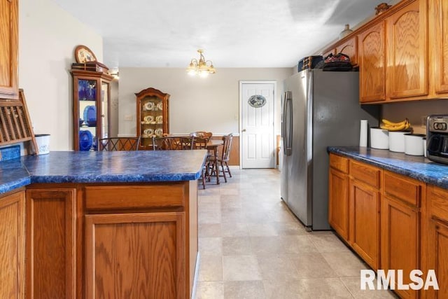 kitchen featuring stainless steel fridge and a notable chandelier